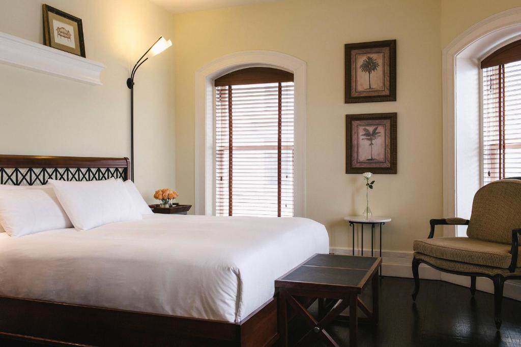 蒙特利尔达尔姆广场酒店的卧室配有一张白色大床和一把椅子