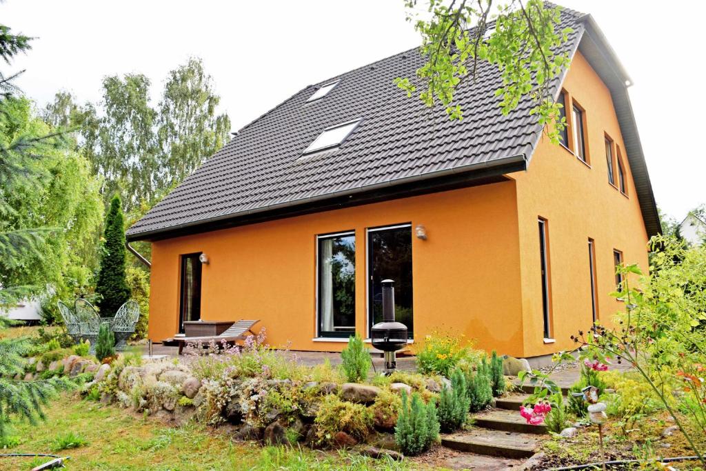 Sandortruhig gelegene Ferienwohnung am Ne的一座橙色的房子,前面有一个花园