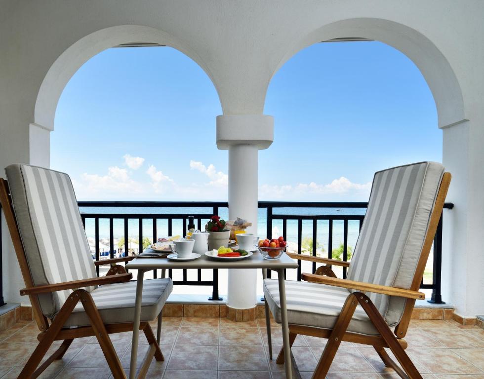 尼基季Assano Seafront Luxury的阳台配有一张桌子和两把椅子