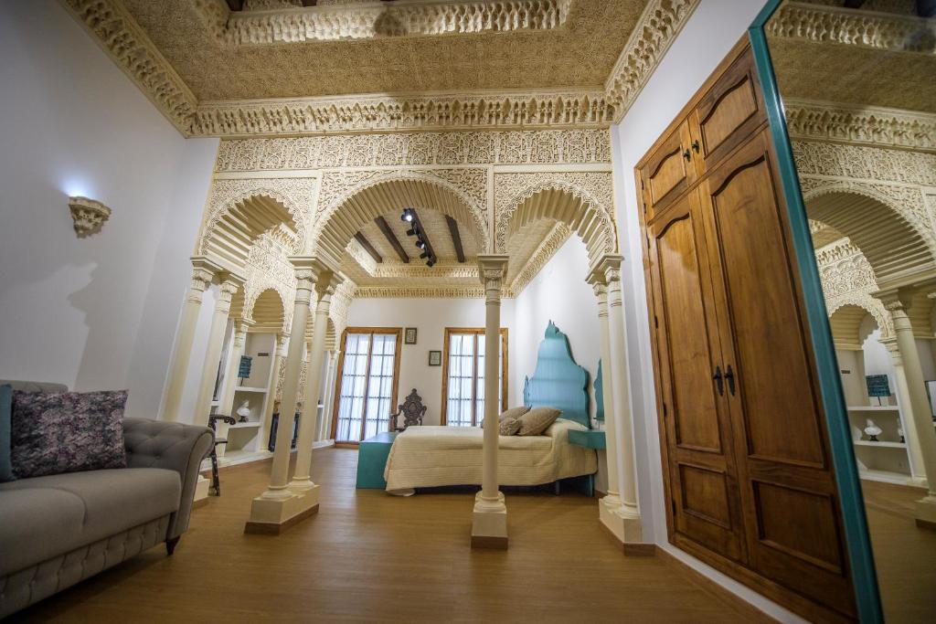 桑卢卡尔-德巴拉梅达Casa Boutique Sanlucar的一间带一张床铺的卧室,位于带拱门的房间