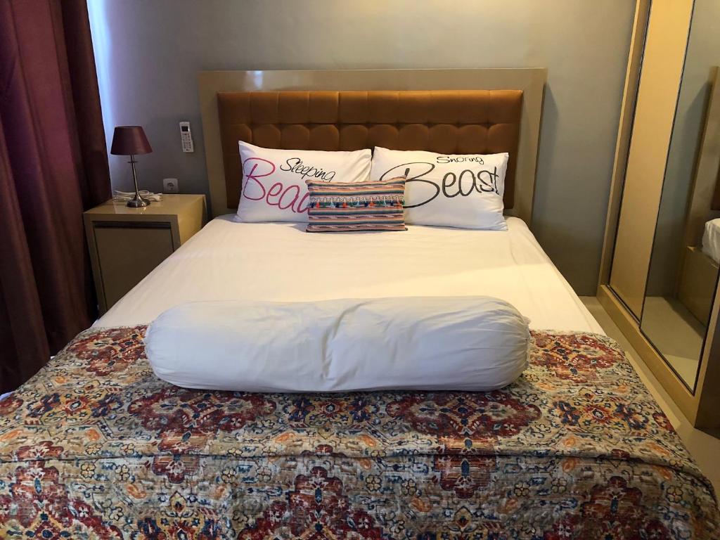 茂物Ruang Bravia Bogor Icon Hotel的一张带白色床单和枕头的床
