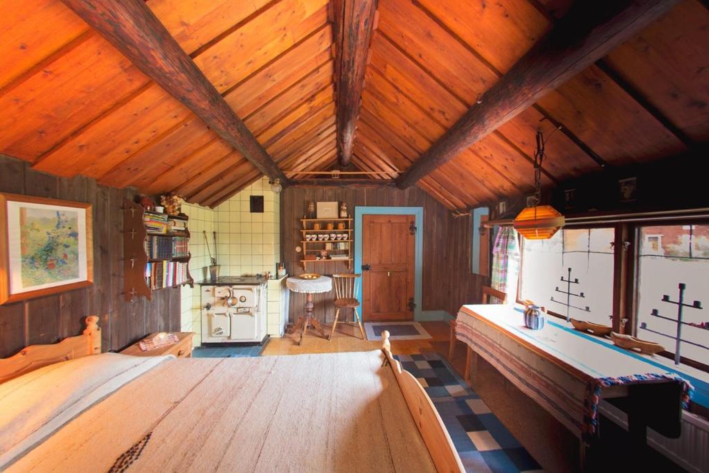 诺尔泰利耶Egen stuga med delat badrum的大房间设有木制天花板和桌子