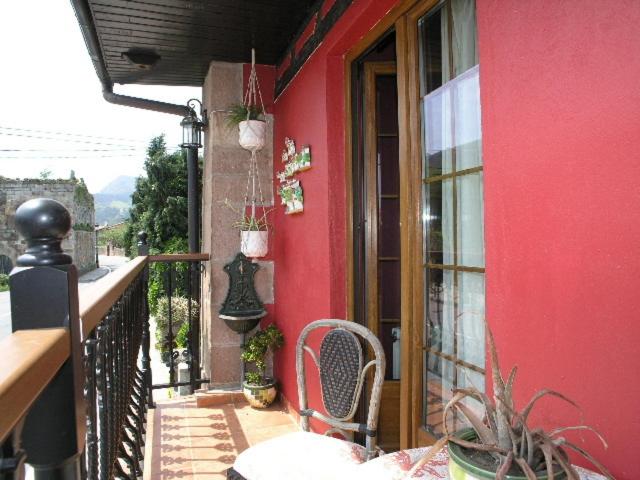 CosPosada Trisileja的阳台的红色建筑,配有椅子
