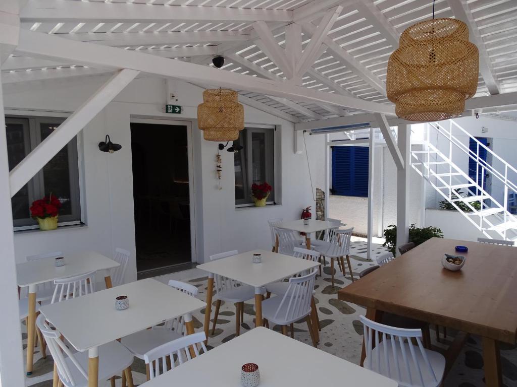 帕蒂迪里奥Galini Hellenic Hospitality的一间设有白色桌子和白色椅子的餐厅