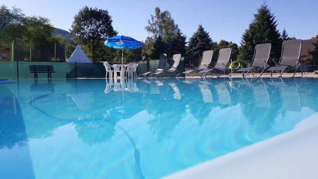 德辛方程式酒店的游泳池里的一组椅子和一把遮阳伞
