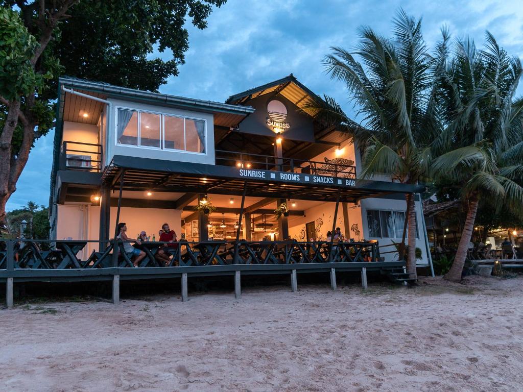 涛岛Sunrise Koh Tao的海滩上的人坐在甲板上的房子