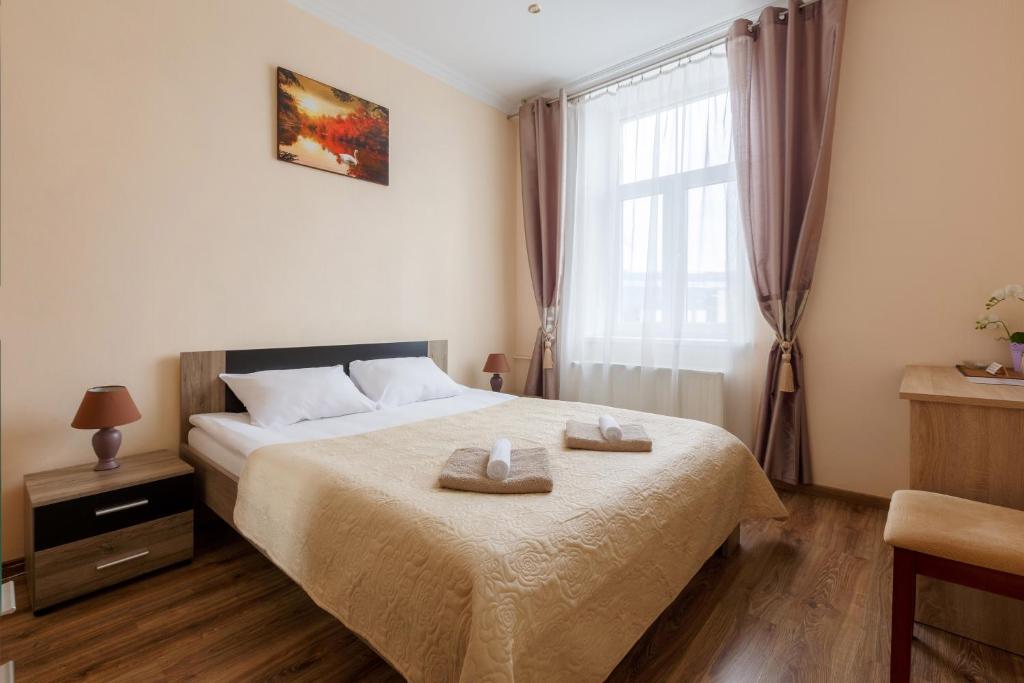 里加Nika Apart Hotel的一间卧室配有一张床,上面有两条毛巾