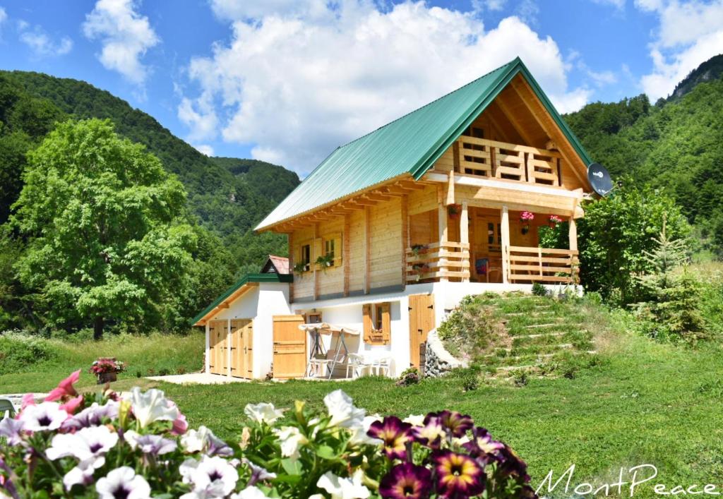 科拉欣Mountain Lodge Mont Peace的花田中带绿色屋顶的木屋