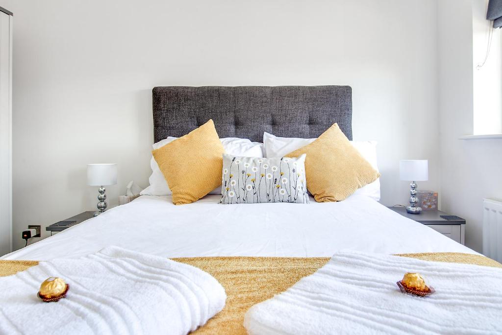 塔姆沃思Westmorland House的卧室配有白色的床和2条毛巾
