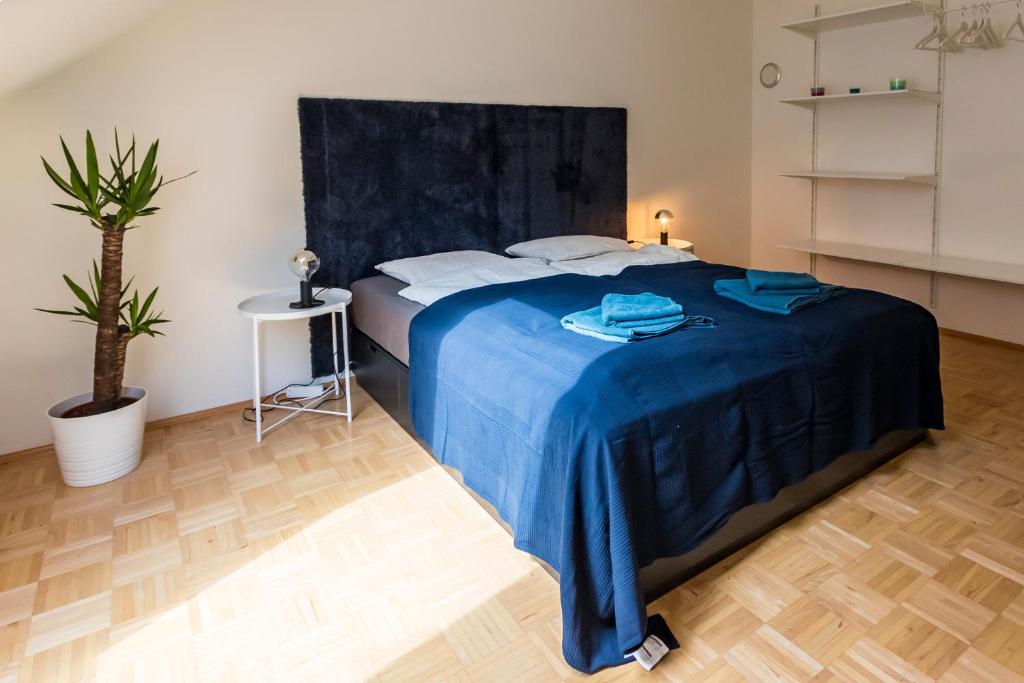格拉茨Flataid Apartment Obere Bahnstraße - Grazer Messe的一间卧室配有一张带蓝色毯子的床