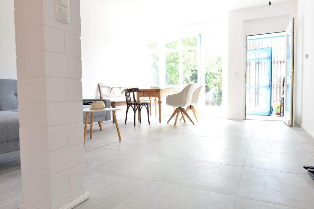 朗克维茨3FLOORS的客厅铺有白色瓷砖地板,配有桌椅。