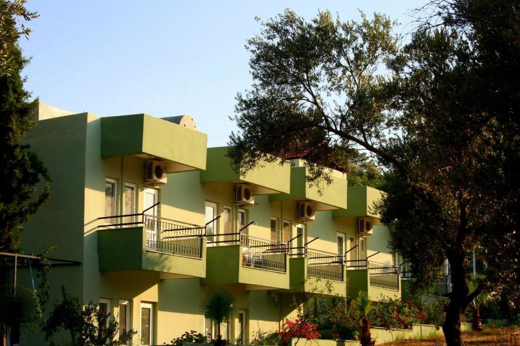 帕塔拉Patara Caretta Hotel的绿色建筑的一侧设有阳台