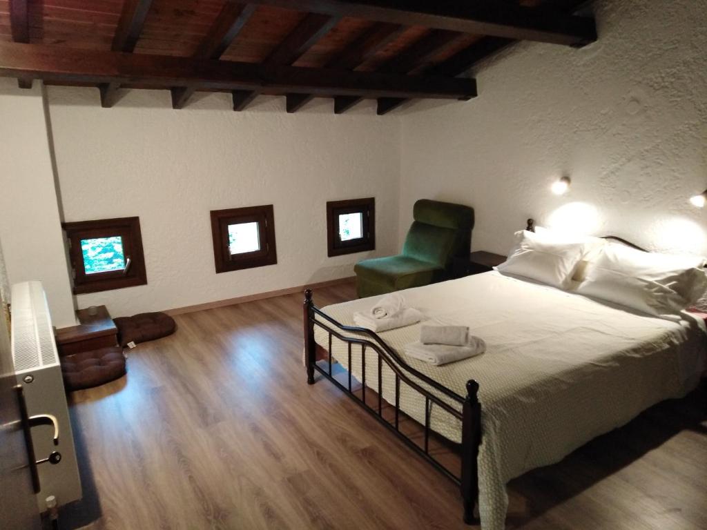 塔克西阿尔希斯艾拉托达索斯农家乐的一间卧室配有一张床和一把绿色椅子