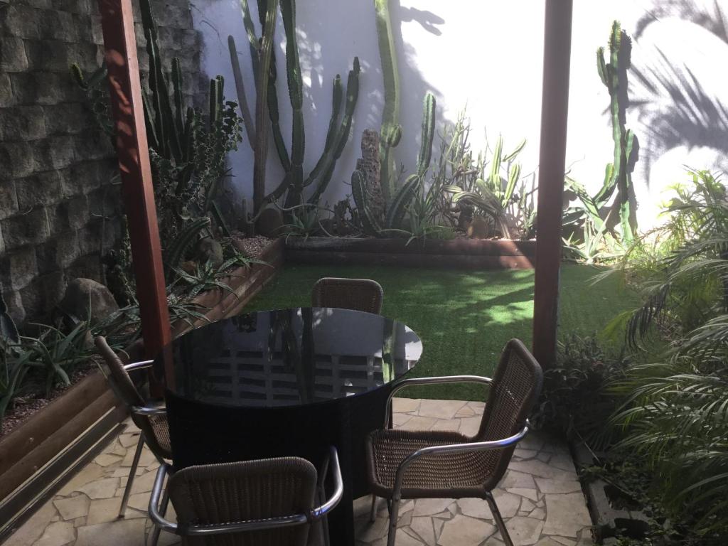 努美阿Résidence les cactus的一个带桌椅的庭院和一个花园