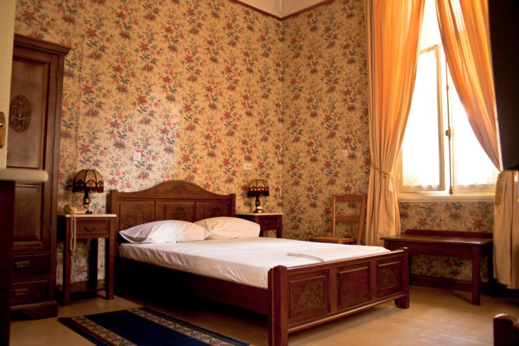 雅典卫城酒店的一间卧室设有一张床和一个窗口