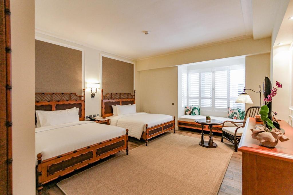长滩岛Feliz Hotel Boracay的酒店客房设有两张床和窗户。