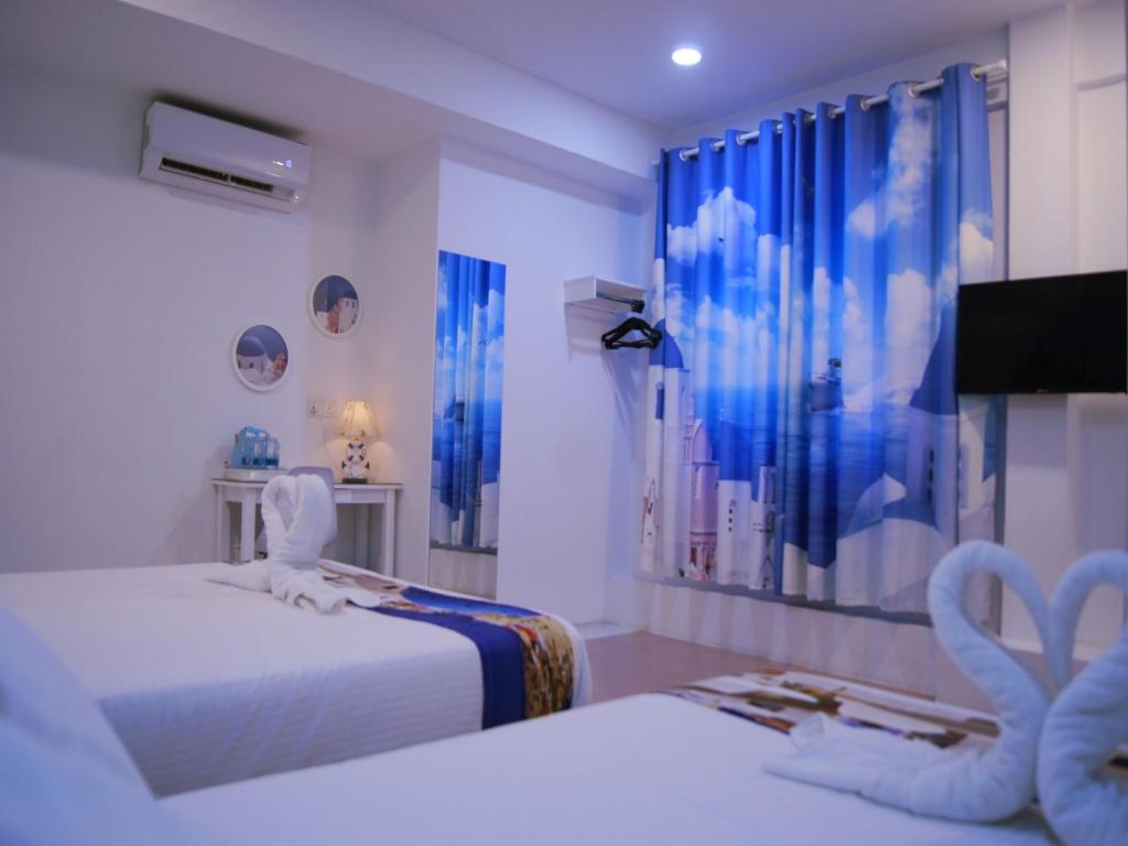 马六甲Santorini Hotel Melaka的一间设有两张床和一台电视的房间