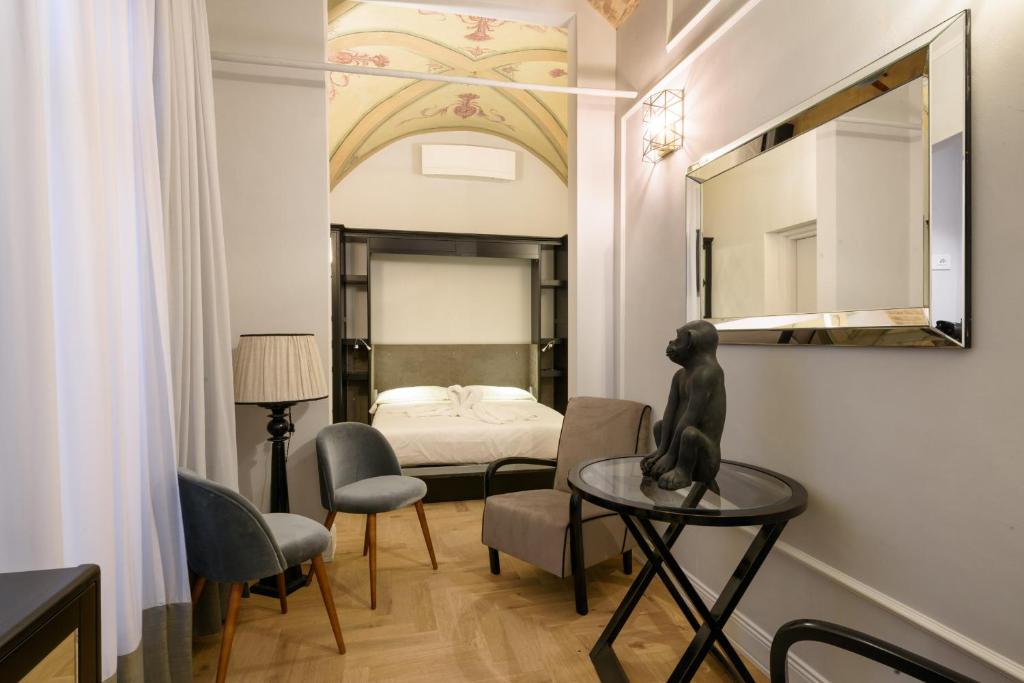 佛罗伦萨Vivaldi luxury suites的一间设有一张床的房间和一张桌子上的雕像