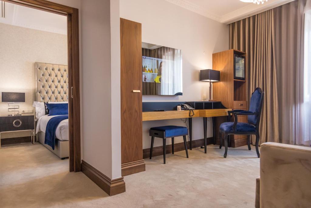 里斯本Casual Belle Epoque Lisboa的酒店客房带一张床铺、一张书桌和一间卧室