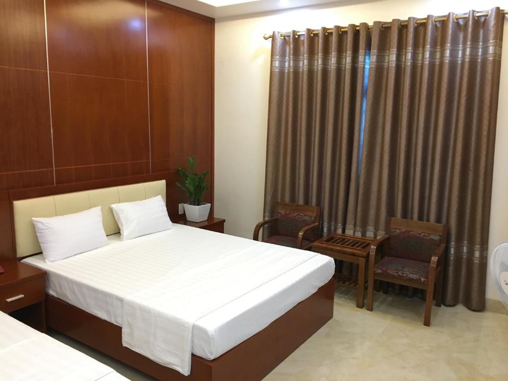 Thái BìnhBình Minh Riverside Hotel的酒店客房,配有一张床和两把椅子