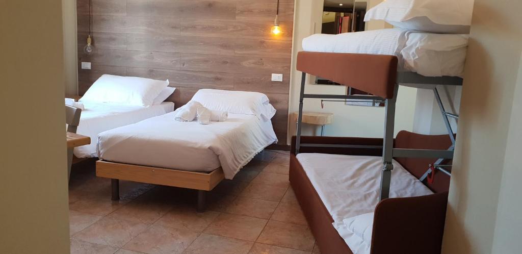 博尔迪盖拉Hotel Raphael的客房设有两张床和一张双层床。