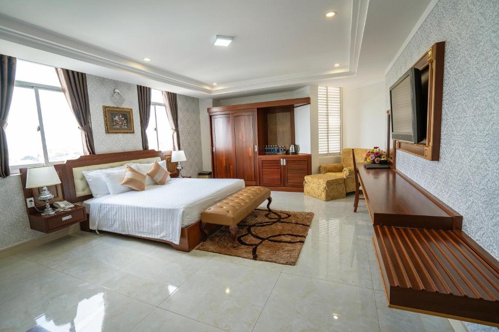 波来古市Duc Long Gia Lai Hotels & Apartment的一间卧室配有一张床、一张沙发和一台电视