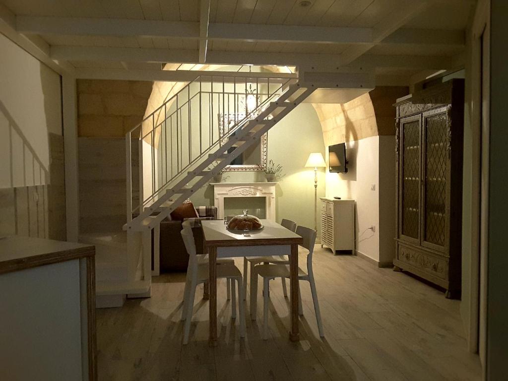 马泰拉SASSO BIANCO的一间带桌子和楼梯的用餐室