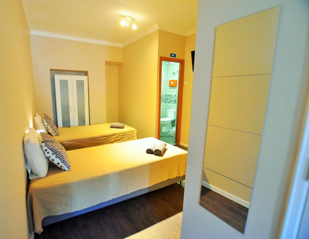 塞图巴尔Rooms DP Setúbal的小房间设有两张床和镜子