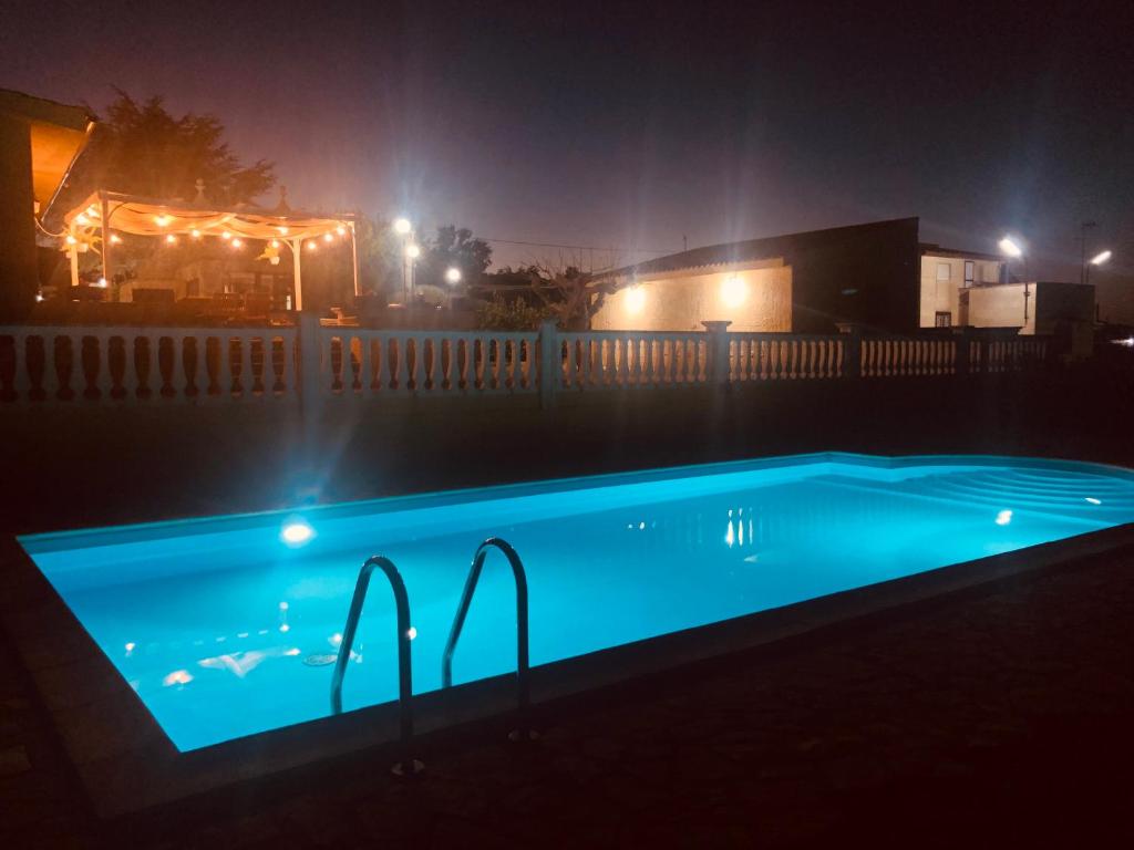 马丁纳弗兰卡TRULLO MANIVA的夜间游泳池,围栏上灯火通明