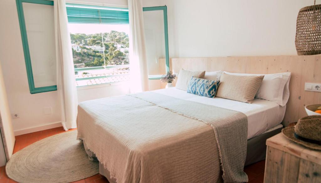 巴古尔Hostal Ses Negres的一间卧室设有一张大床和一个窗户。