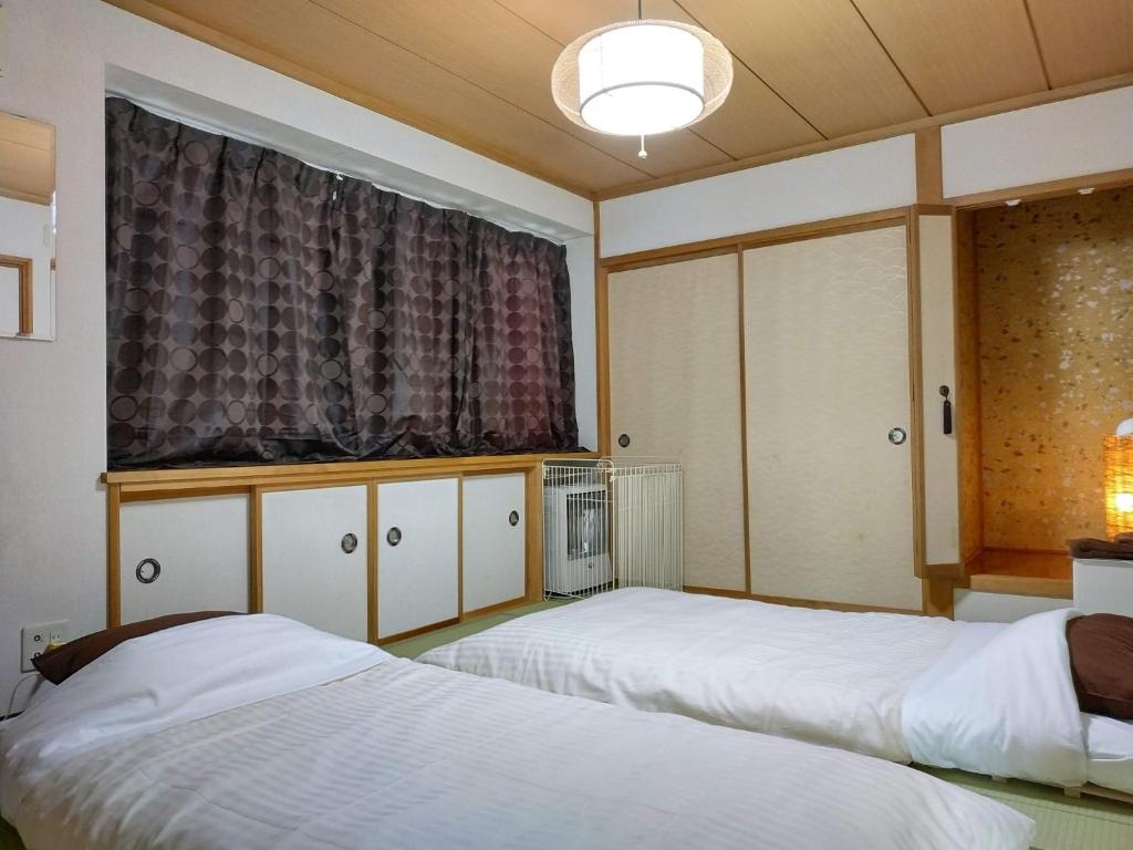 小樽Bay View House private room / Vacation STAY 3667的一间卧室设有两张床和窗户。