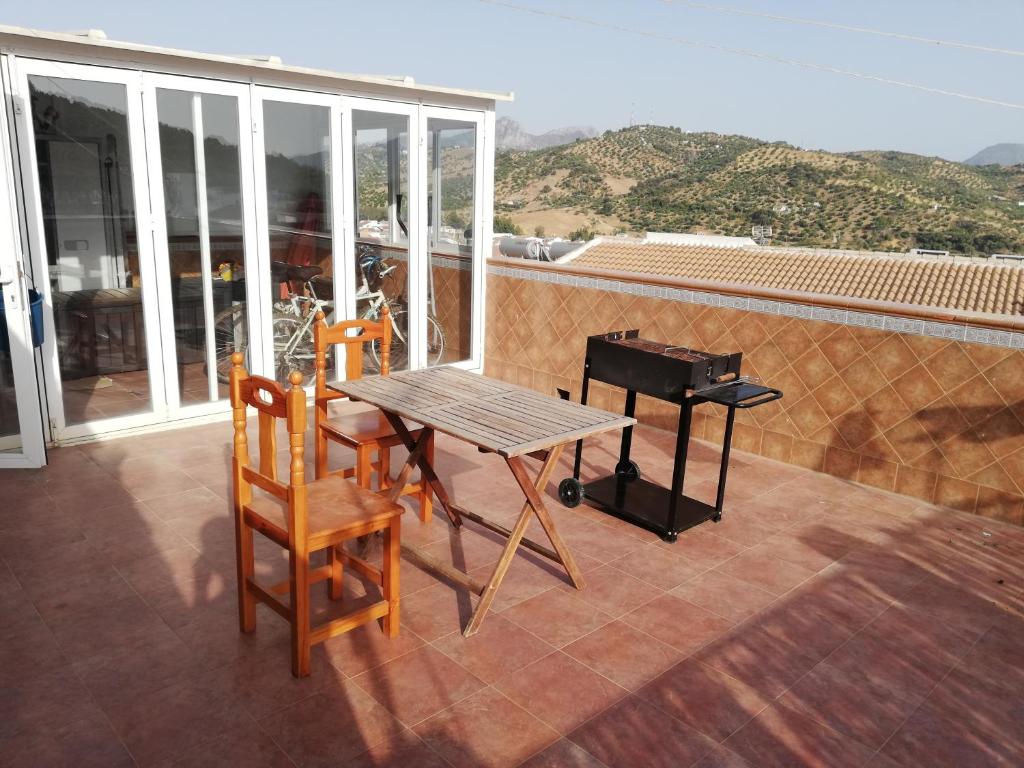 阿尔戈多纳莱斯Atico centrico ideal en Algodonales的阳台配有桌椅和钢琴