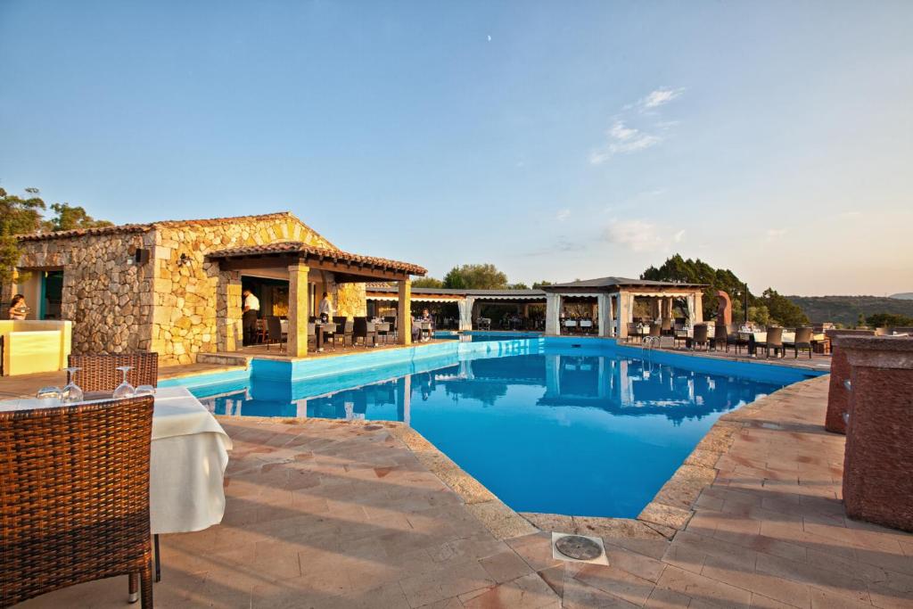 罗通多港Residence Stella Di Gallura的一个带桌椅的度假村游泳池