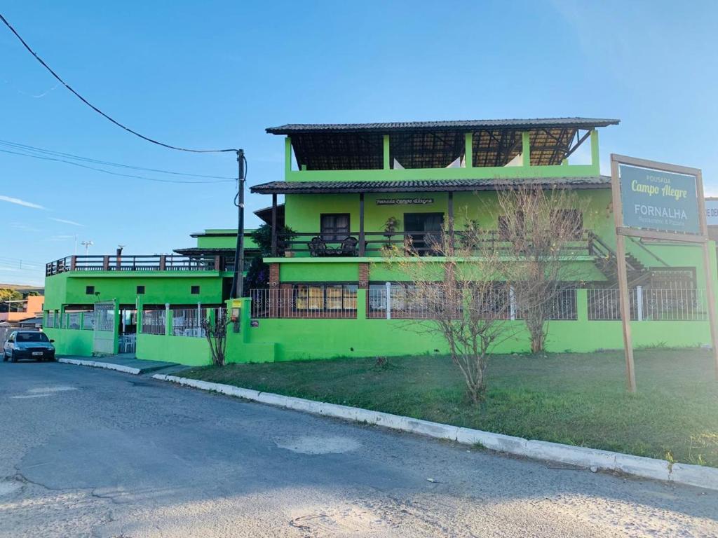 伊塔蒂亚亚Pousada Campo Alegre的前面有标志的绿色建筑