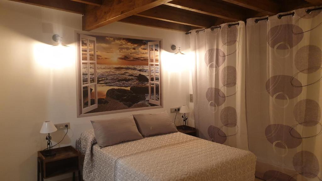 阿尔姆尼卡Hotel SAN SEBASTIAN Almuñécar的卧室配有一张床,墙上挂有绘画作品