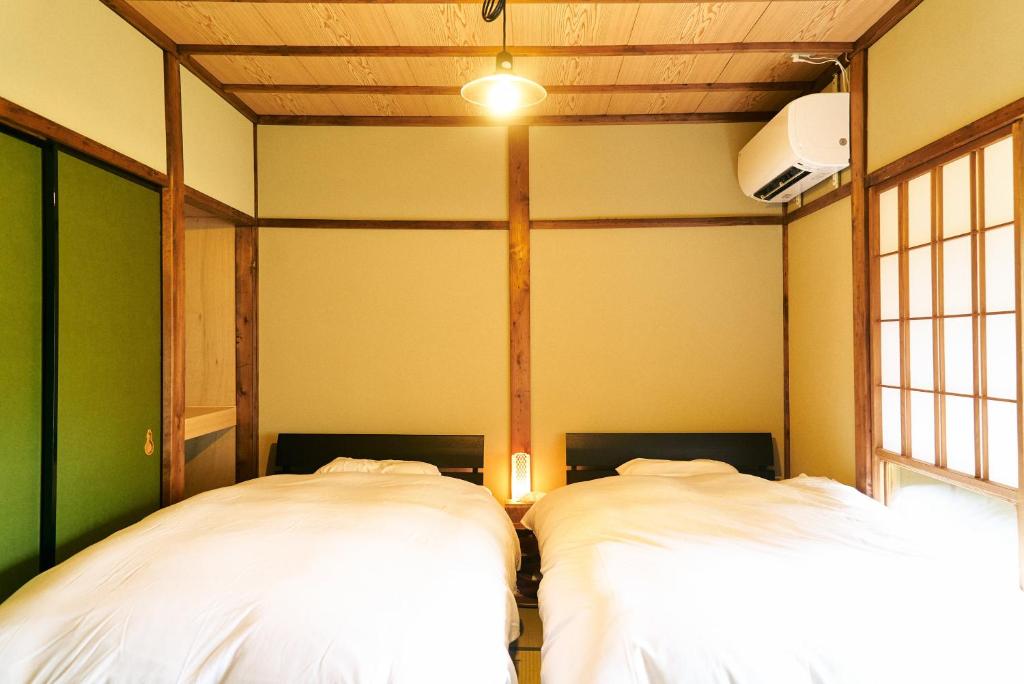金泽Hyotan TABI-NE的客房角落的两张床