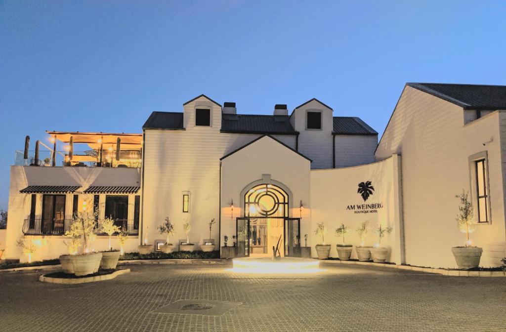 温特和克The Weinberg Windhoek的一座白色的大建筑,前面有一个庭院