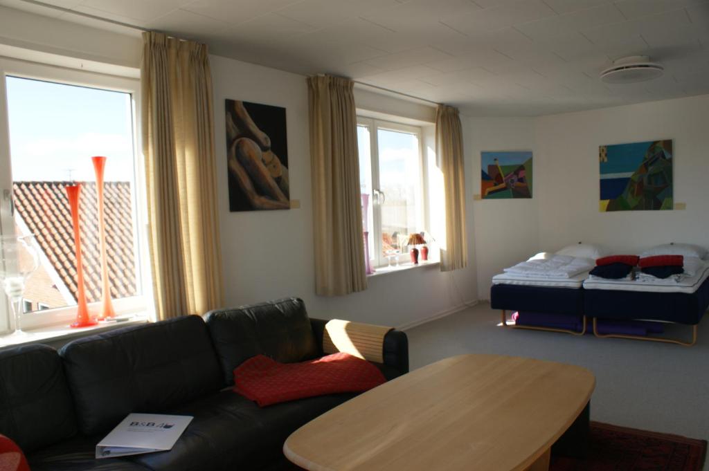 SejerslevStor lys lejlighed på Nordmors的客厅配有沙发、桌子和床。