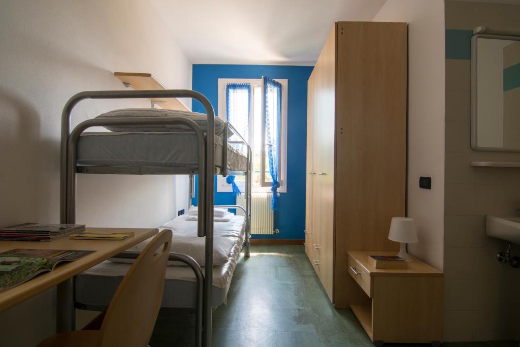 巴萨诺－德尔格拉帕奥斯特洛格拉怕旅舍的客房设有两张双层床和一张书桌。