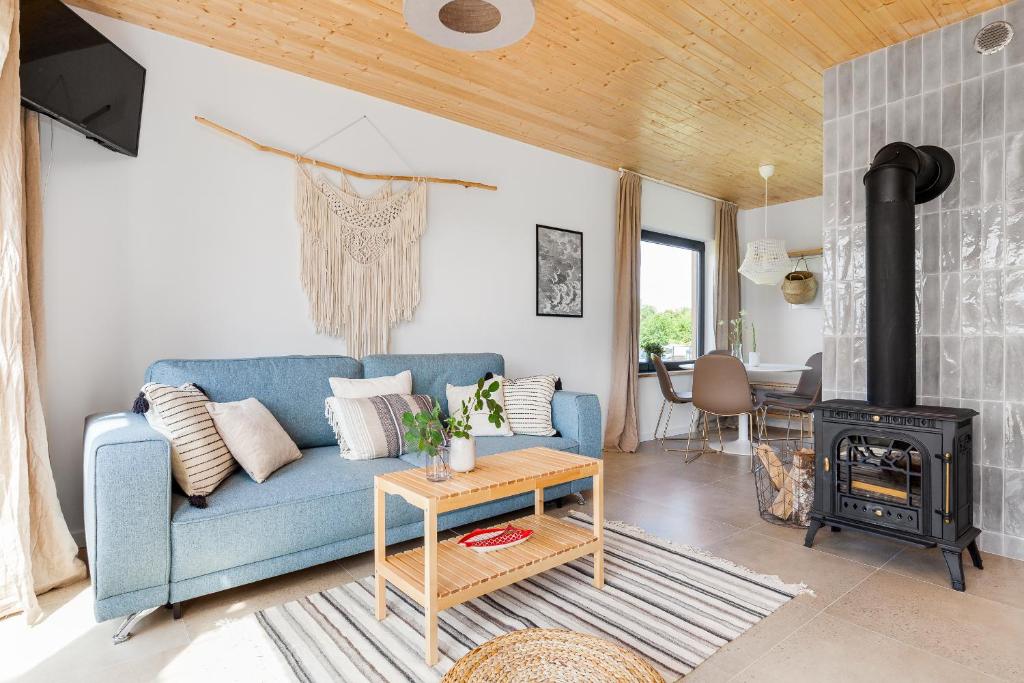 加茨比亚格拉Domki ROSSE niedaleko plaży的客厅配有蓝色的沙发和燃木炉。