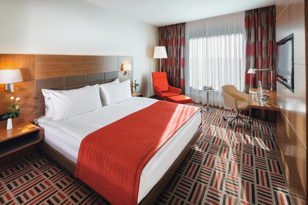 安卡拉莫文皮克安卡拉酒店的酒店客房带一张大床和一把椅子