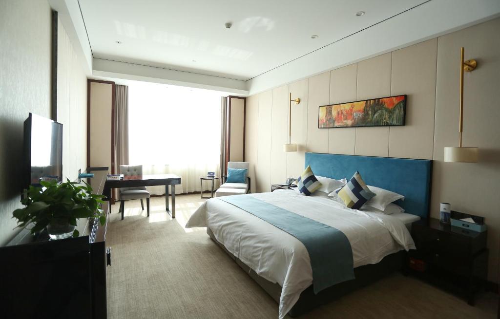 忻州忻州戴斯酒店的酒店客房设有一张大床和一张书桌。