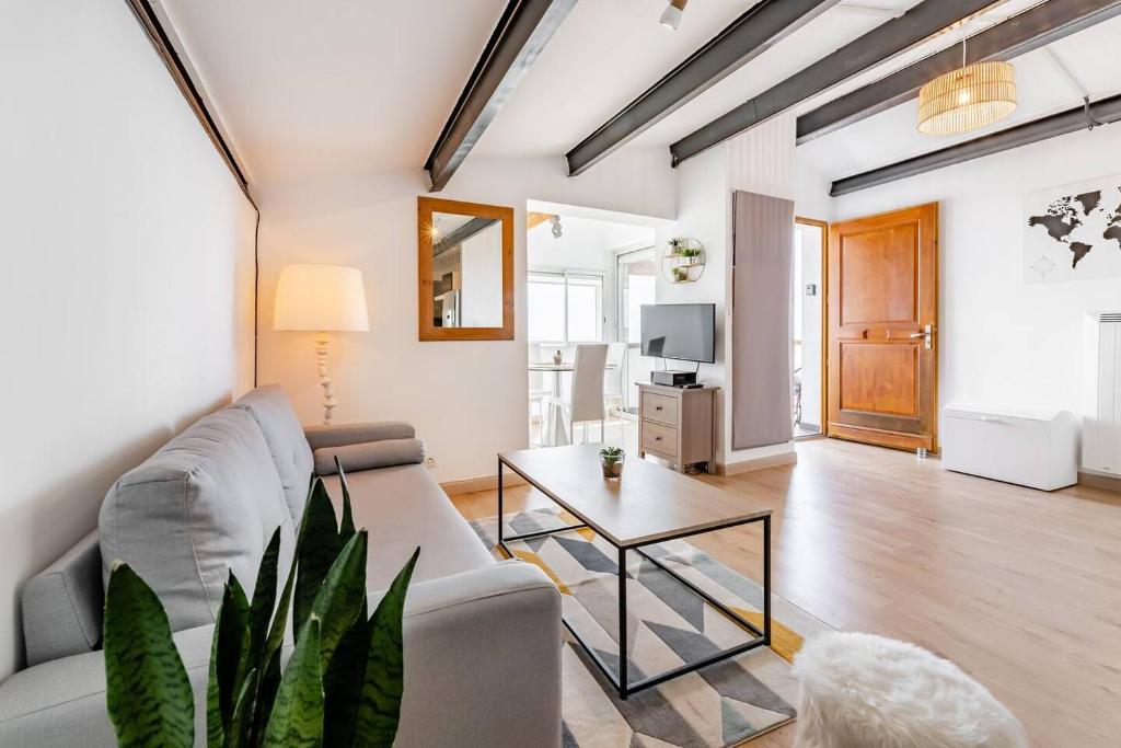 马赛Appartement cosy Verduron vue mer panoramique的客厅配有沙发和桌子