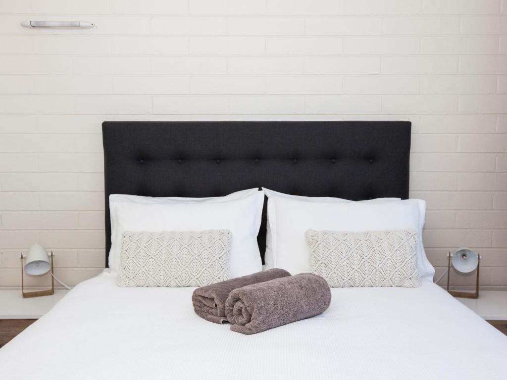 斯卡曼德鹈鹕金沙斯卡曼德汽车旅馆的一张白色的床,上面有一条毛巾