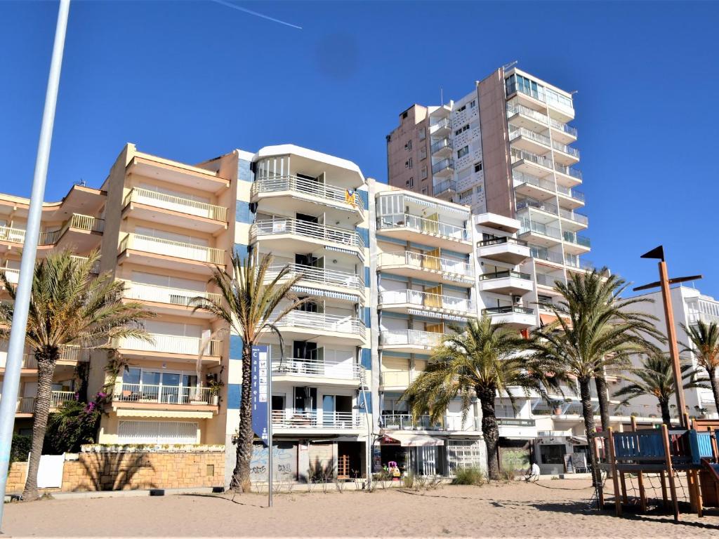 卡拉费尔Villa Service - Poblet的一座大型公寓楼,前面有棕榈树
