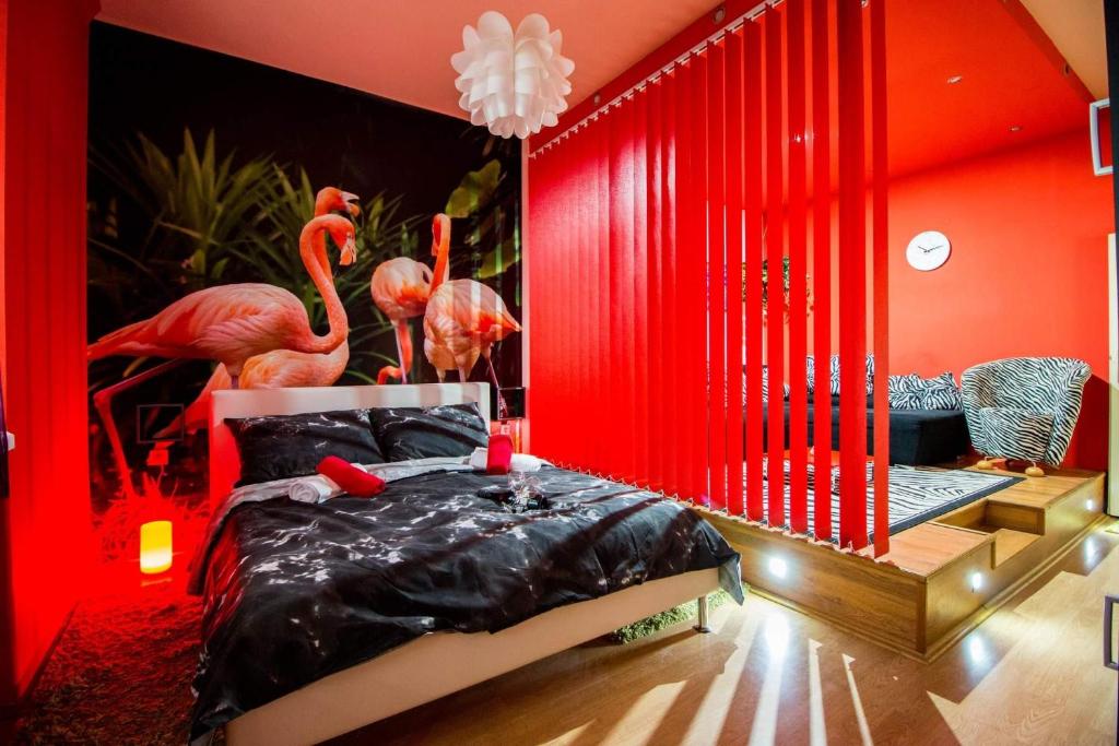 奥西耶克FLAMINGOS Apartman & Fitness OSIJEK - blizina Bolnice KBC Osijek的红色卧室配有带火烈鸟的床