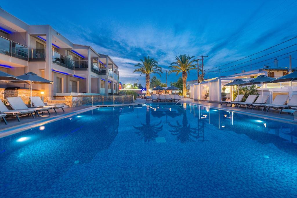卡尼奥提Dionysos Hotel & Suites的一个带椅子的游泳池和一间酒店