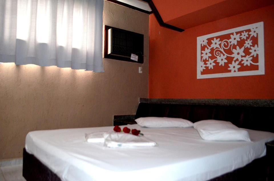 尤西德福拉Motel & Hotel Free Love JF的一间卧室配有一张带白色床单和红色墙壁的床。