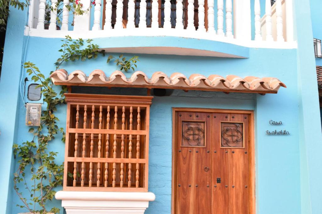 蒙波斯Casa Isabelita的蓝色的房子,设有木门和阳台