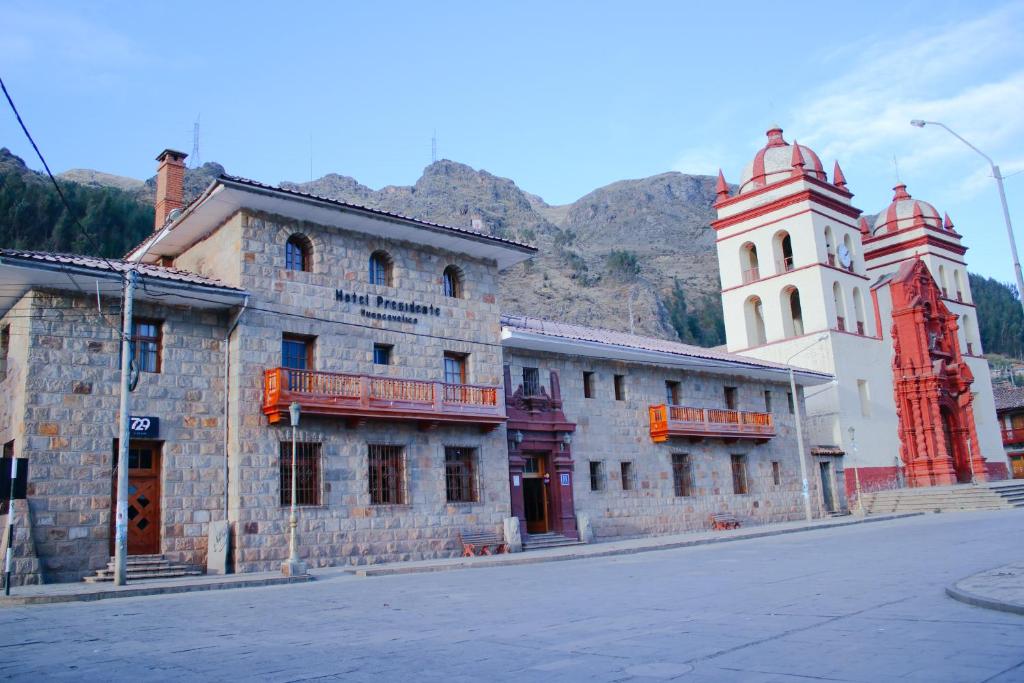 HuancavelicaHotel Presidente Huancavelica - Asociado Casa Andina的两座塔楼街道边的一座老建筑